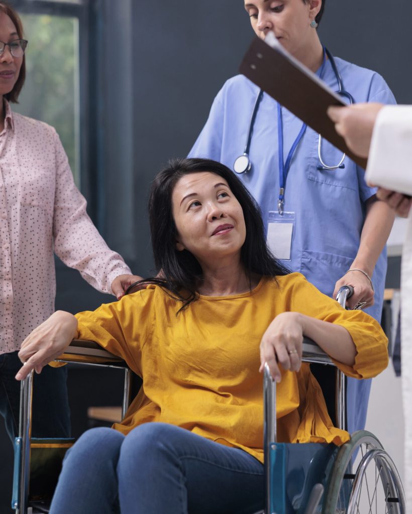 Senior specialist discussing with injured patient before medical consultation in hospital waiting area. Physician doctor giving medical advice to asian woman during rehabilitation exam. Medicine support